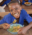 Boy in school in Ghana eating lunch